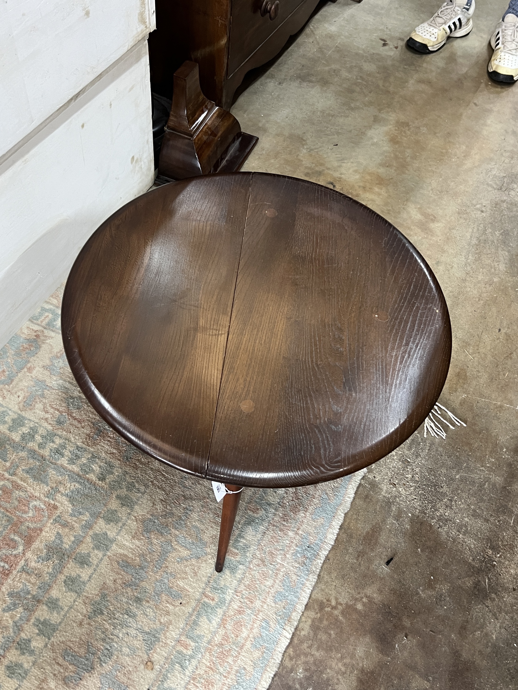 An Ercol elm single drop leaf occasional table, diameter 61cm, height 40cm